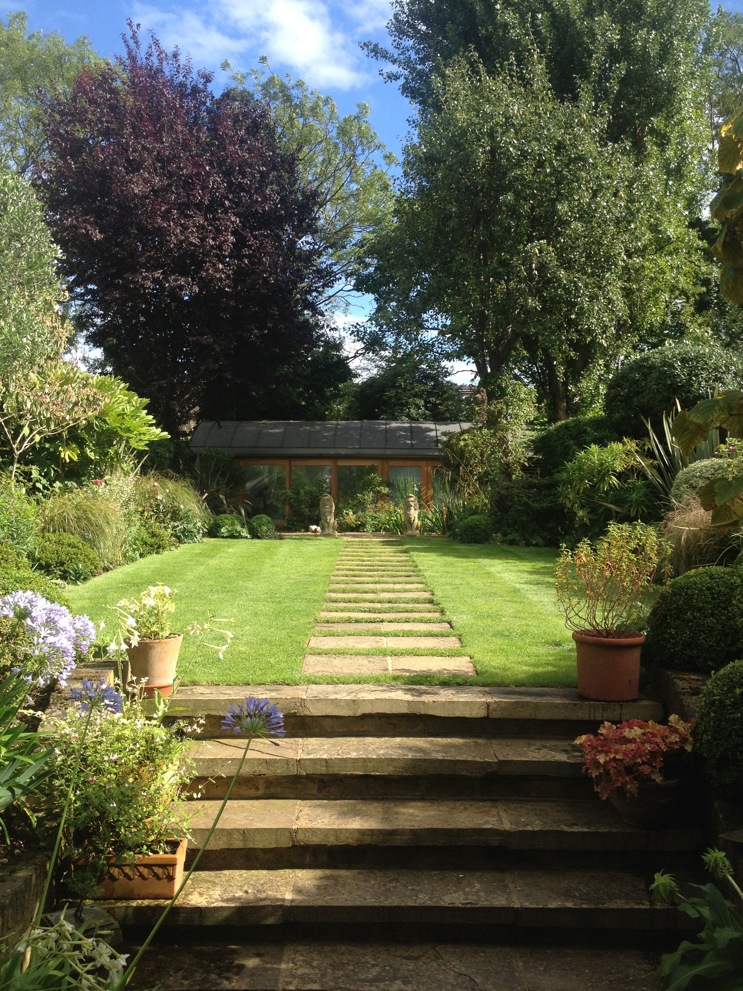 Expert lawn care and precision edging for a multi-level London garden. Holmes Gardens maintains structural turf integrity alongside artisanal stone steppers, ensuring a seamless transition between hardscaping and lush greenery.